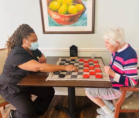 Chef playing checkers with senior